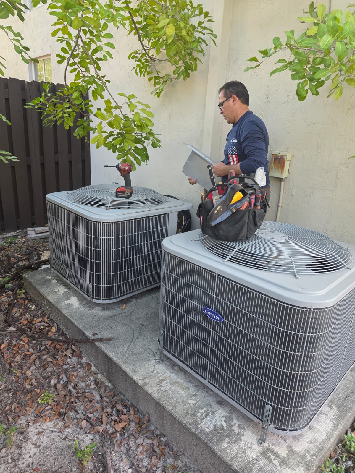 Licensed technician servicing Carrier AC condenser units